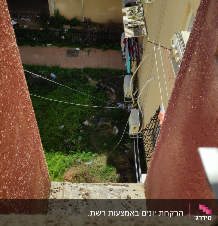 מזגנים מותקנים על קיר בניין עם כביסה תלויה